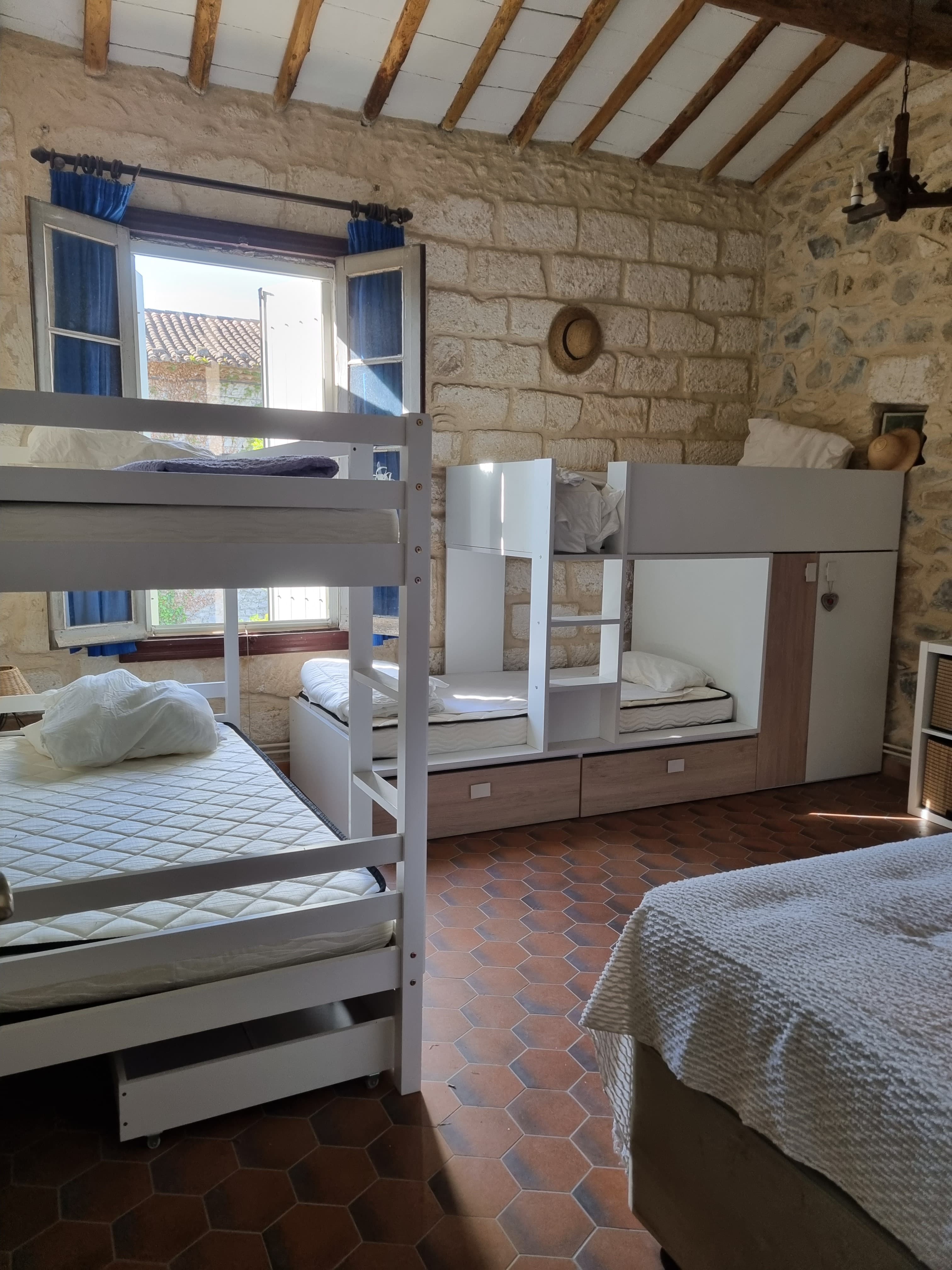 The Guardians Room — white bunk beds and cabin bed unit in a stone-walled room