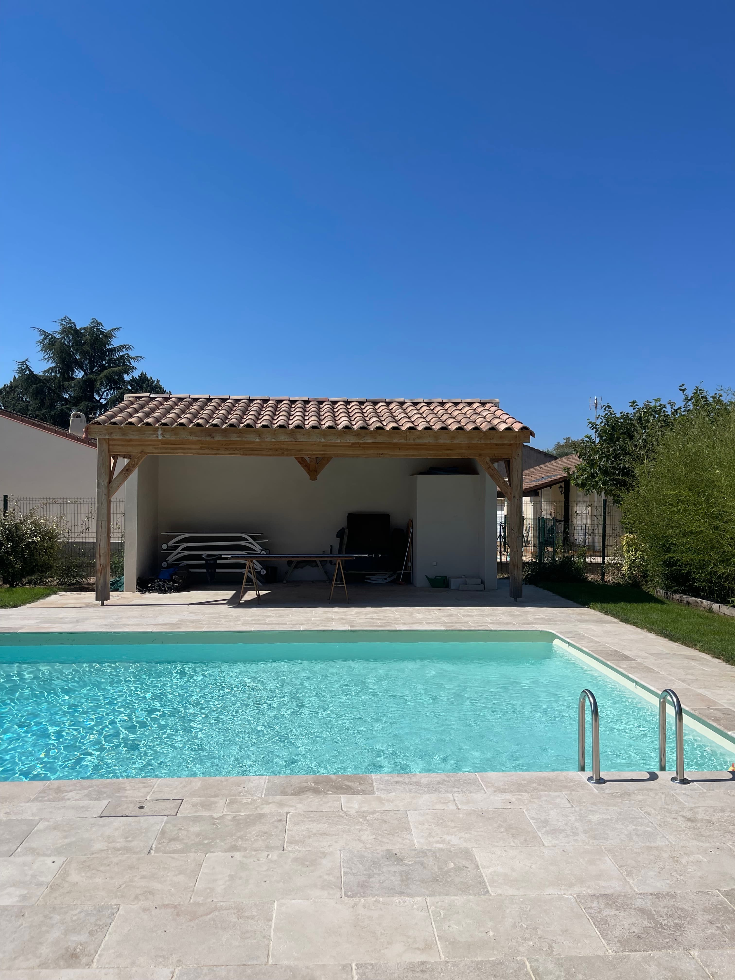 The 12-metre pool with limestone surround and pool house in full sunshine
