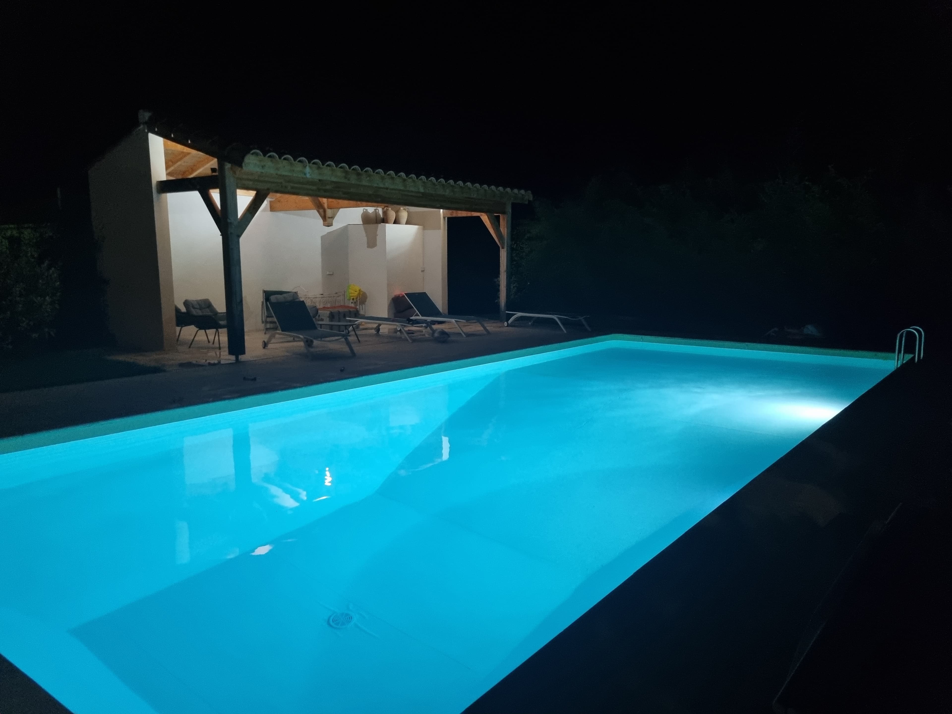 The pool glowing electric blue from underwater lighting at night