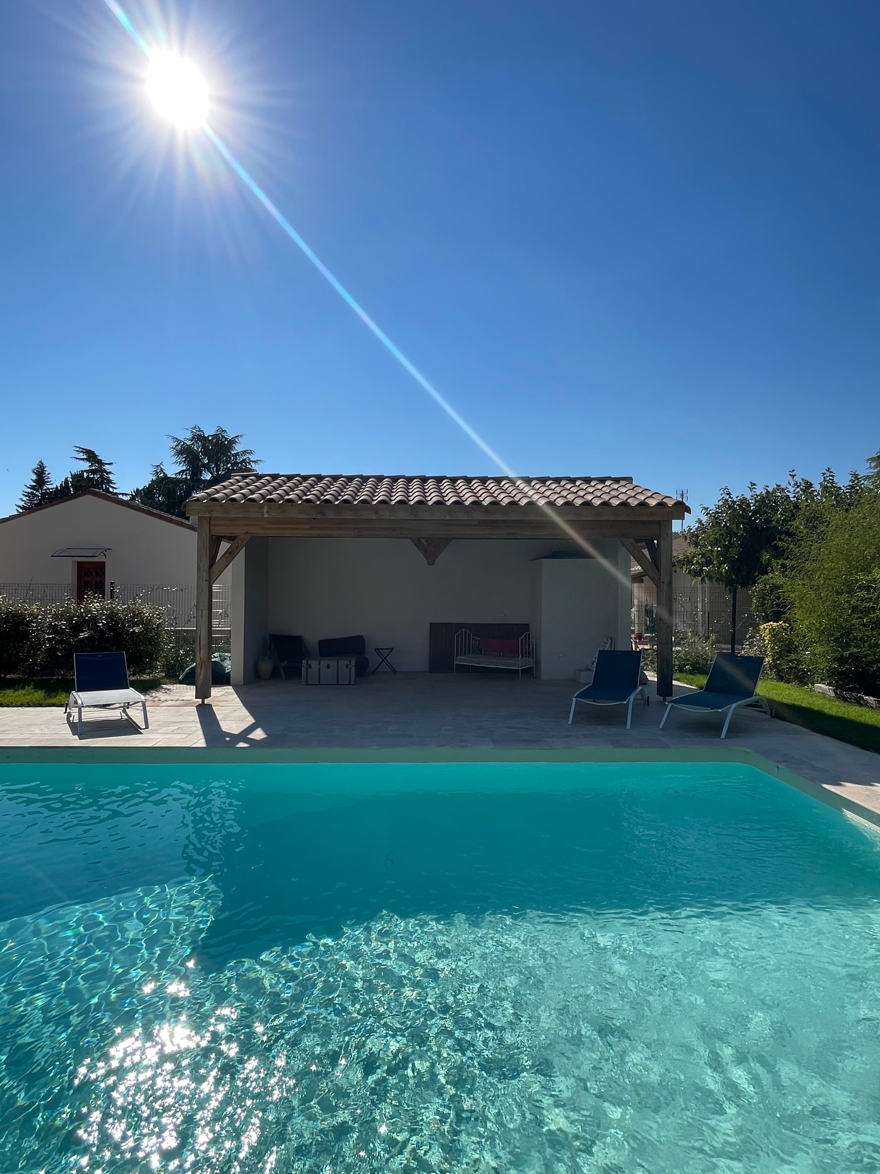 Pool and pool house bathed in dazzling summer sunshine